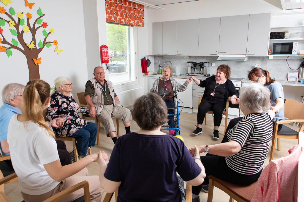 ikäihmiset yhdessä jumppaamassa tuoleilla istuen