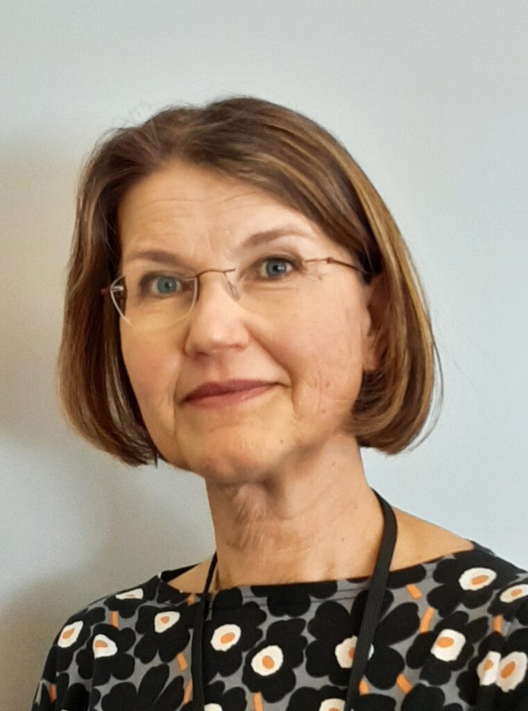 Valokuva Mervi Lehmusahosta, kuvassa ruskeahiuksinen polkkatukkainen silmälasit omaava nainen katsoo kameraan,kuva on rajattu näyttämään kasvot ja hiukan olkapäitä.