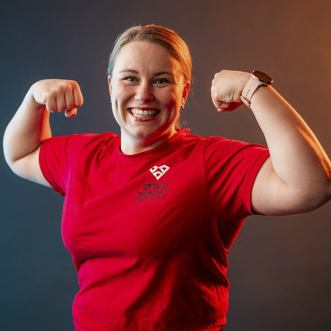 Henkilökuva ensihoitajanaisesta, joka tekee bodausliikkeen käsillään.