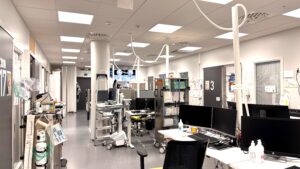 Päivystyksen tila, jossa hoitajien ja lääkärien koneita sekä hoitohuoneiden ovia.