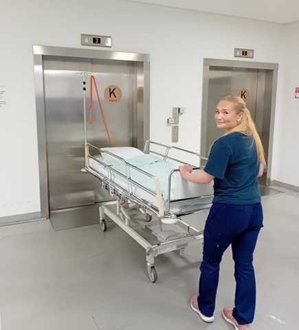 Pauliina Vesterinen työntää sairaalasänkyä hissiä kohti.